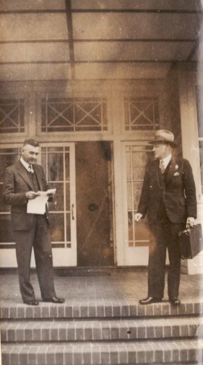 Charles Daley and Thomas Reeve, both dressed in suits, standing on steps in front of a building, possibly the Hotel Canberra.