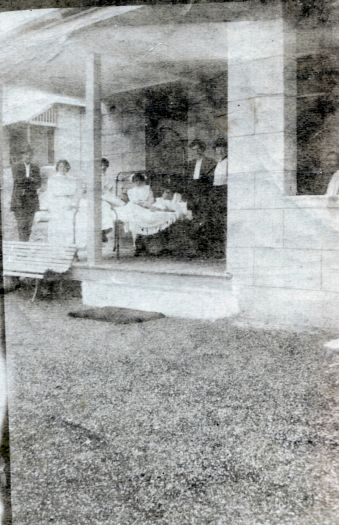 Group of nurses and patients standing on a verandah