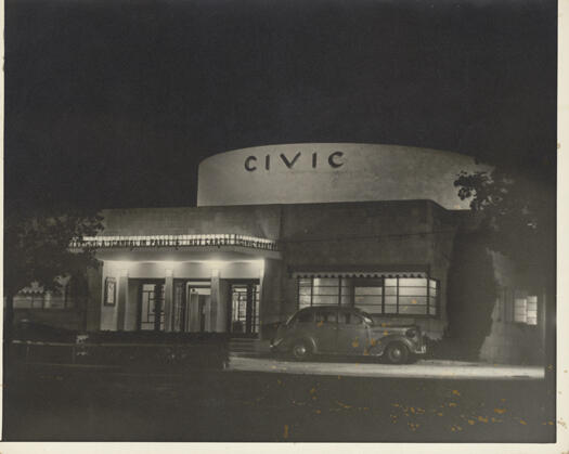 Civic Theatre showing the entrance with the word 'Civic' above the entrance. The photo was taken at night and the entrance is well lit. The two movies being shown are 'A Scandal in Paris' and 'Hot Cargo'.