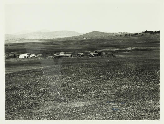 View of an early Canberra farmhouse, probably Rottenbury's Farm, and five stacks of hay.