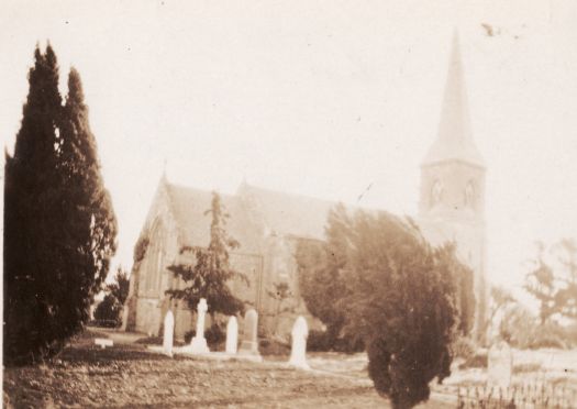 Side view of St John's church and churchyard showing headstones