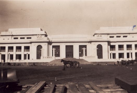 Front view of old Parliament House with horse and dray outfits in foreground