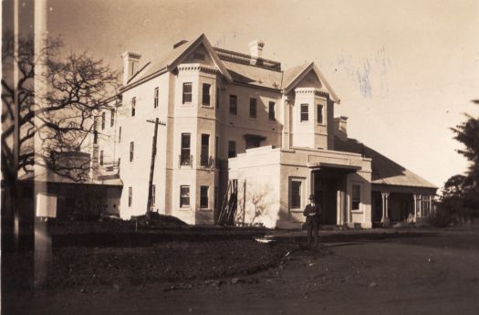 Front view of Yarralumla House with unidentified man in foreground; photograph possibly taken in 1920s