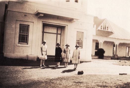 Partial side view of Yarralumla House with four unidentified women; photograph possibly taken in 1920s