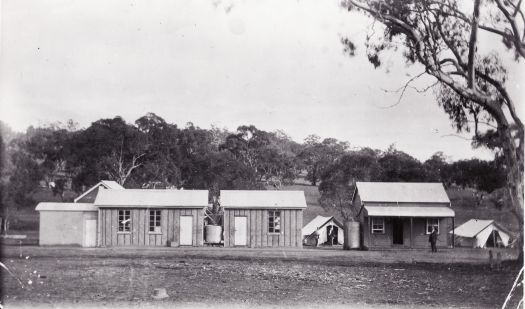 Survey camp on Kurrajong Hill. Three buildings and two tents can be seen. 
