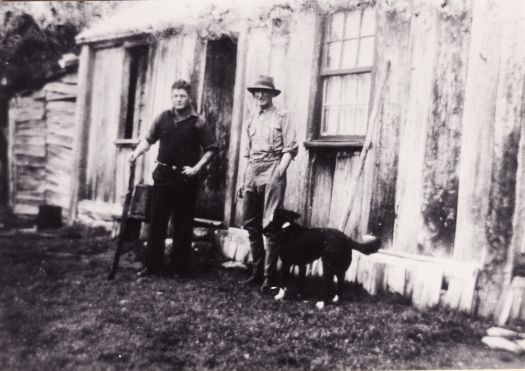 Two men and a dog outside the Cotter Hut