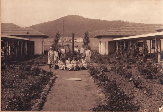 Group at Gorman House. Second from left (sitting) is Mrs A. Nish. The Hotel Ainslie is in the background.