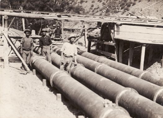 Cotter Dam pipeline under construction showing three workmen