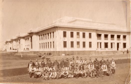 Group of workmen in front of the completed Parliament House