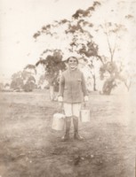 \"The Canberra Milkman\" was a young Gordon Kaye. The photo shows him carrying two pails of milk.