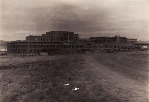 Parliament House under construction, taken from the rear south west side, showing rolling stock and construction railway.