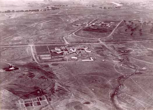 Aerial view of Parliament House under construction from west over Hotel Canberra.