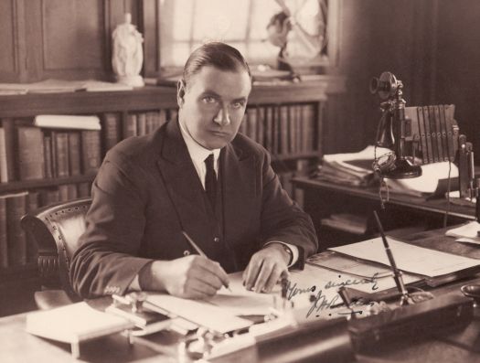 Sir John Butters - Federal Capital Commissioner - at his desk signing papers