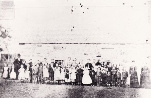 St. John's Schoolhouse with students and teachers outside. The school closed in 1907