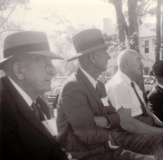 Photograph of three people. Left to right: Unknown, John Shumack, Samuel Shumack.