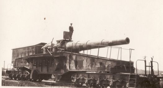 German gun used in World War 1 in France. A man is standing above the barrel.