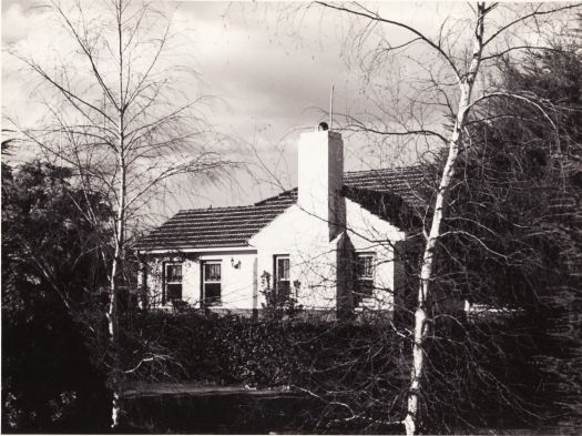 A Federal Capital Commission era house with two leafless trees in the foreground suggesting winter.