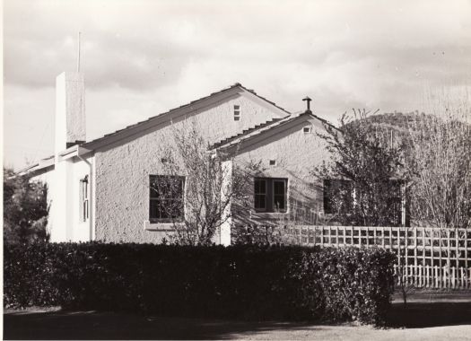 A Federal Capital Commission era cottage with garden in front \, possibly taken in winter. 