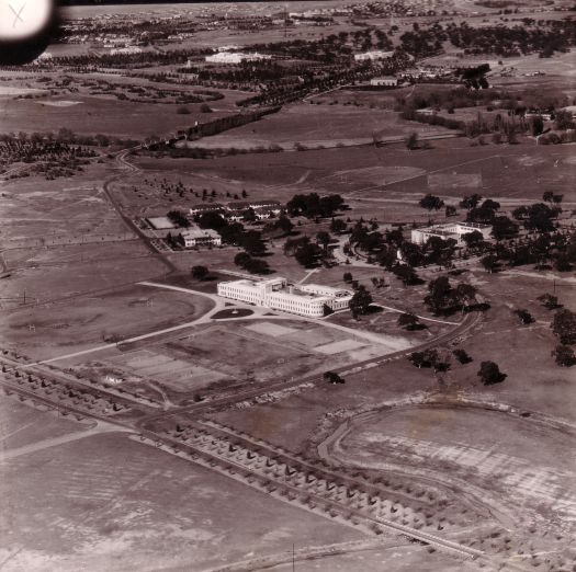 Aerial photograph c1940 showing Canberra High School looking towards Parliament House and the Albert Hall. University Avenue runs across the front of the photo.