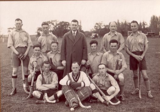 Charles Daley (in coat) with unnamed members of a men's hockey team.