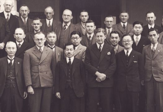 Group of men including J.H. Starling, George Knowles, C.L. Abbott, Col Hodgson, R.R. Garran, C.S. Daley with group of Japanese in front of Hotel Canberra
J Collingridge