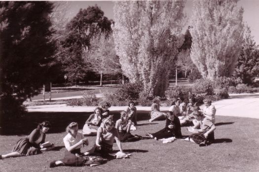 Group of women sitting in the sun on the lawns in front of Albert Hall