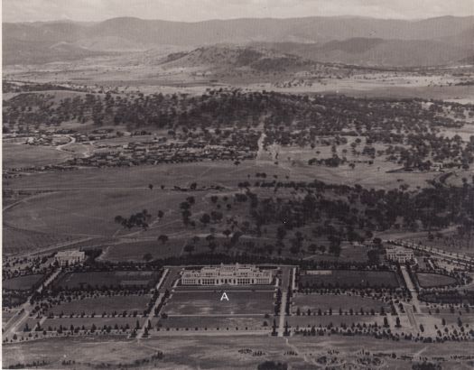 Aerial view to south over Parliament House to Red Hill and Mt Taylor showing East Block and West Block and the King George V statue site marked by an A.