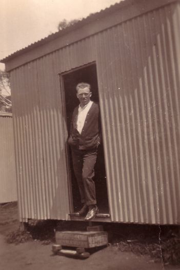 W.S. Kellie standing in the doorway of a hut Howies Camp.