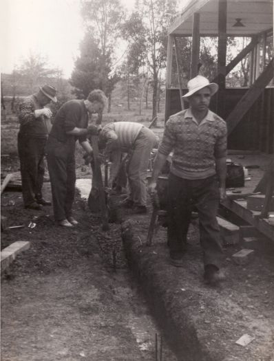 Construction of the Russian Orthodox Church in Narrabundah. Photo shows three men and one woman laying foundations for the building.