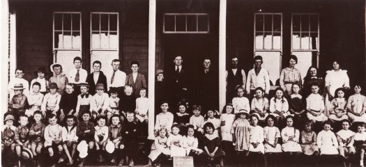 Group photo of students of the Duntroon Public School at the front of the building. The teacher, David S. Jones, is in the middle. There are 56 boys and girls in the photo.