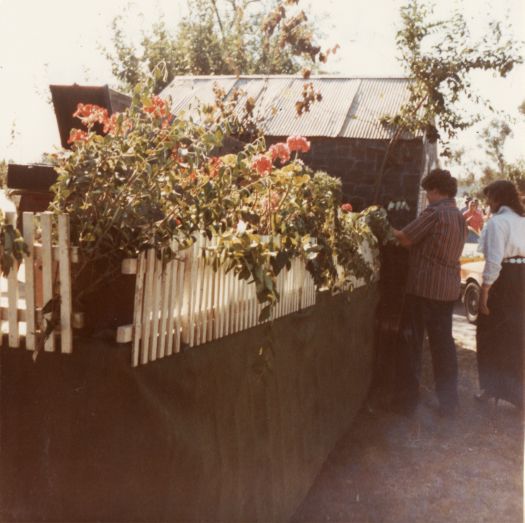 Canberra Day Festival - Anne Brace, Cynthia Southwell adjusting flowers on the CDHS Blundells Cottage float for the Canberra Day parade