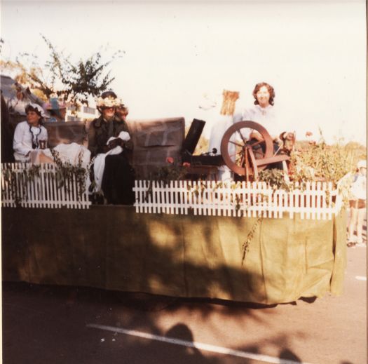 Canberra Day Festival - CDHS Blundells Cottage float with three women in period costume and a spinning wheel and old record player.