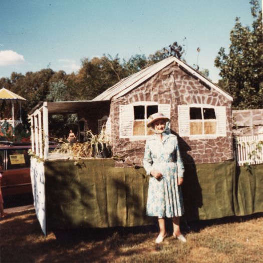 Beryl Southwell standing in front of the CDHS Blundell's Cottage float which was built over Kingsley Southwell's truck