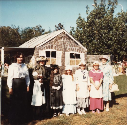 Canberra Day Festival - CDHS float for the Canberra Day Parade showing three women and four girls in period costume with a Blundells Cottage float at the rear