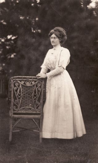 Unidentified woman standing beside chair