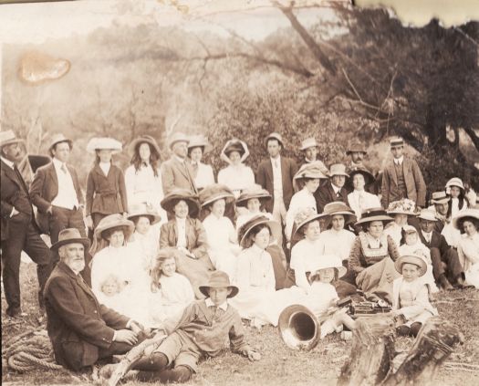 Picnic at Kambah Pool, Murrumbidgee River, Tuggeranong. About 30 men, women and children posing for a group photograph. There is a tuba lying on the ground in the foreground. On the back is written 'Susan Maxwell'. and a notation 'dgthr T.P. Maxwell'.

Bottom left: Patrick Joseph Bede Donnelly, Aimee (nee Massy) Donnelly, Marguerite (Rita) Donnelly, Monica Donnelly, James Donnelly.