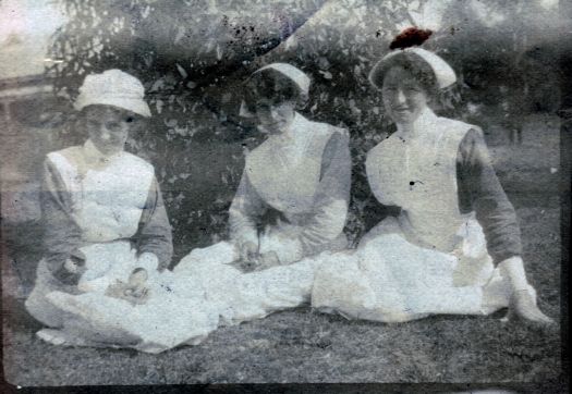 Three nurses sitting on the ground, one is "Susan"