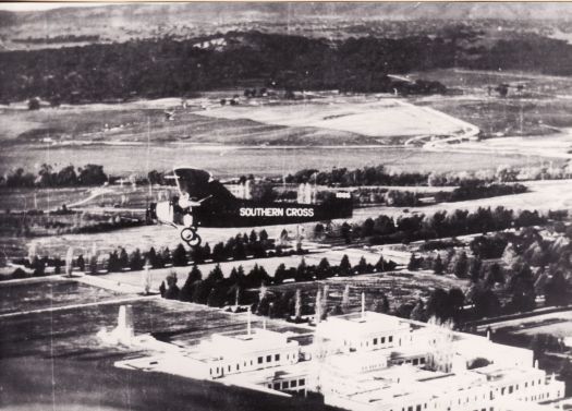 Aerial photograph of the 'Southern Cross' flying over Parliament House in June 1945 prior to the filming of a movie about Charles Kingsford-Smith.