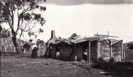 A woman is standing near an old deserted hut at Majura