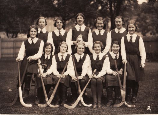 School girls hockey team showing twelve players in uniform.