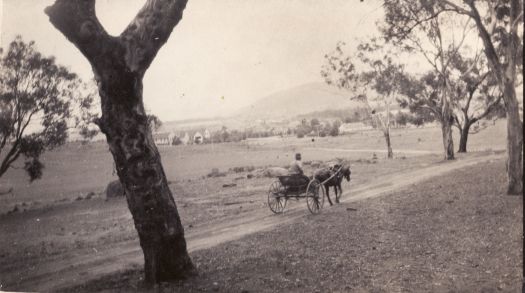 Horse and buggy on the old track from Yass to Queanbeyan, Ainslie Hotel in the background
