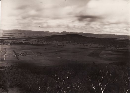 View from Mt Ainslie, looking towards Black Mountain. Pre-dates housing in Braddon. Trees in Haig Park have been planted.