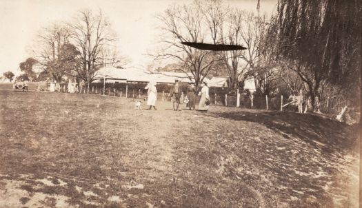 Jeir Station, old house with four people standing on the lawn