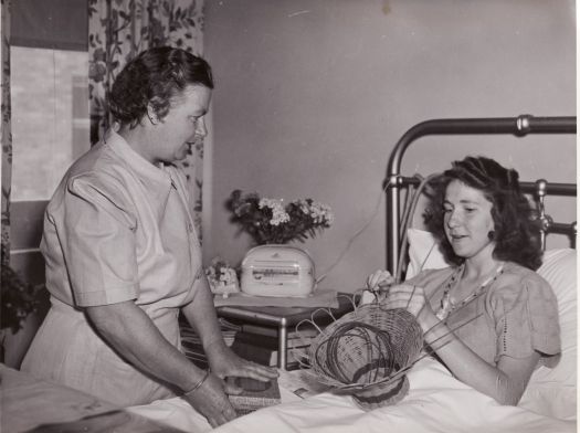 Occupational therapy, Canberra Community Hospital showing a nurse talking to a woman in bed who is making a basket