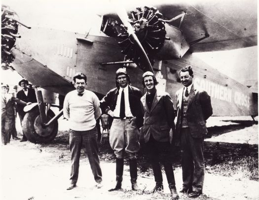 Four men posing in front of the Southern Cross plane before its 1928 Pacific flight. L to R: Harry Lyon (navigator), Charles Ulm (co pilot), Charles Kingsford Smith (pilot), James Warner (radio operator).