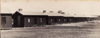 A long row of portable cottages at Acton, showing the front of the buildings.