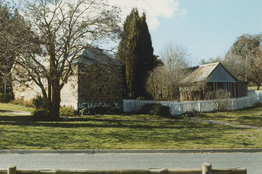 Side view of Blundell's Cottage with Wendouree Drive in the foreground.