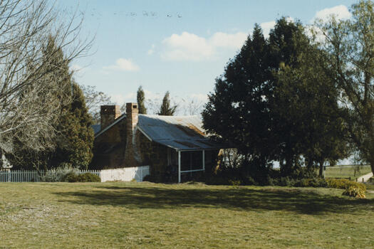 Right side view of Blundell's Cottage showing the white picket fence in front of the building.