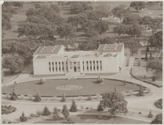 Aerial view of the Institute of Anatomy, McCoy Circuit, Acton, now the home of ScreenSound Australia. Shows open woodland behind the building, where the Australian National University (ANU) now stands, with a circular driveway in front of the building.
