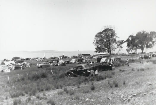 Lake George Sailing Club regatta - showing cars parked on the edge of Lake George with boats in the background.